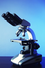 Microscope on table, on color background