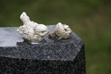 Zwei Vogelfiguren auf einem Grabstein