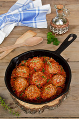Fried meatballs with tomato sauce and spices in frying pan