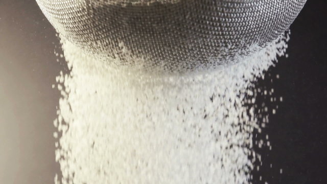 Sifting wheat flour through sieve