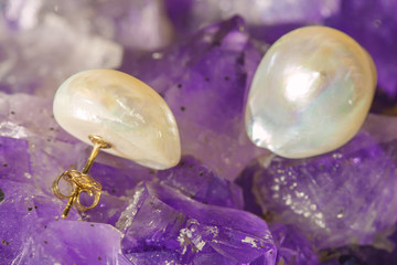 Pearl earrings on ametyst background