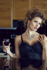 Fashionable woman in the kitchen with glass of wine