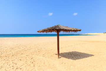 Beach scenery with parasol in Boavista, Cape Verde
