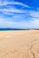 Fototapeta na wymiar Sand dunes near to the ocean with cloudy blue sky, Boavista, Cap