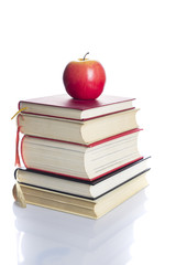 Books tower with red apple isolated on white background