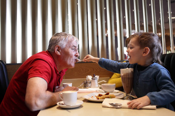 Grandchild feeds his grandfather