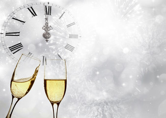 Glasses with champagne and clock close to midnight