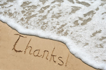 Conceptual thank you text in sand and water
