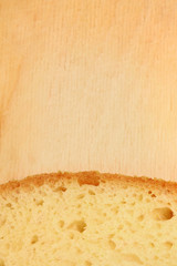 Close-up image of slice of white bread against the wooden board