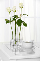 Beautiful bouquet of flowers in vases on window background