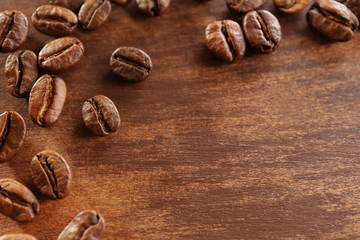 Coffee beans on wooden background, close-up