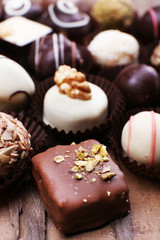 Many chocolates on wooden textured background