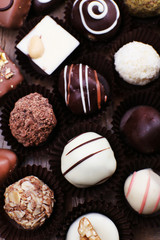 Many chocolates on wooden textured background