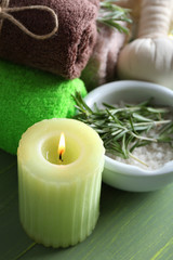 Branches of rosemary and sea salt, towels, candle and bottle