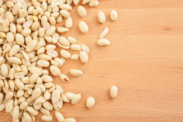 Peeled peanuts on wood background