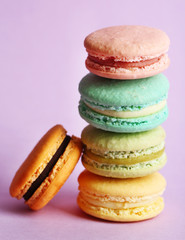 Assortment of gentle colorful macaroons on color background