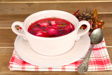 Traditional polish clear red borscht with dumplings in bowl