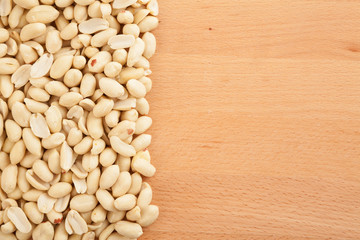 Peeled peanuts on wood background