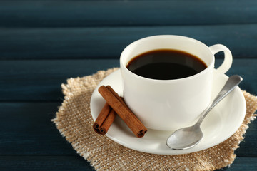 Cup of coffee with spoon and cinnamon