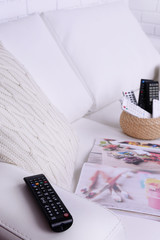 Many remote control devices on sofa