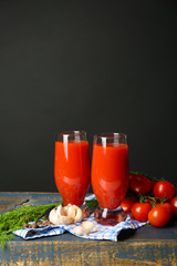 Glasses of tasty tomato juice and fresh tomatoes