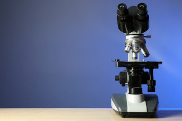 Microscope on table, on color background