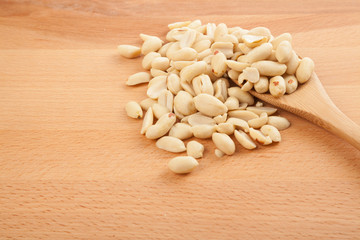 Peeled peanuts with wooden spoon