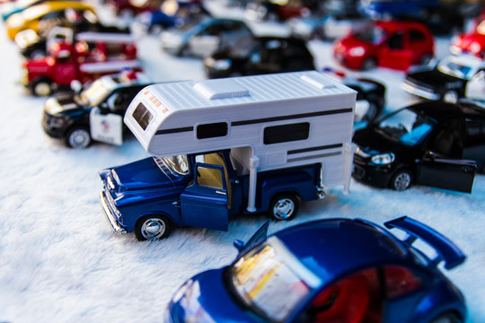 Toy cars are placed in rows for sale with a truck,