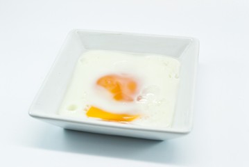 fried egg in white bowl isolated before white background
