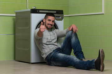 Young Man Doing Housework Laundry Thumbs Up Sign