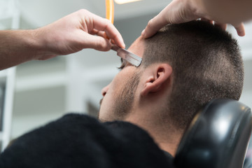 Hairdresser Shaving Man's Chin With A Straight Razor