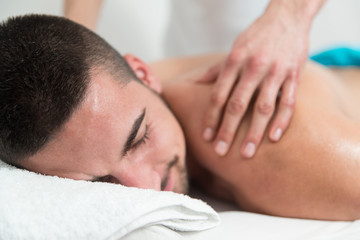 Fototapeta na wymiar Good-Looking Man Getting A Back Massage Lying Down