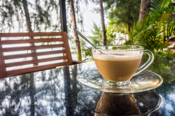 A glass cup of coffee on granite stone table