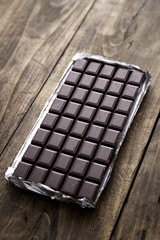 Dark chocolate bar in opened silver foil