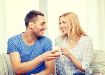 smiling man giving cup of tea or coffee to wife