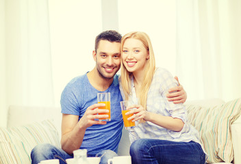 smiling happy couple at home drinking juice