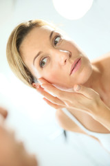 Fototapeta premium Middle-aged woman applying anti-aging cream