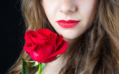 Labbra con rosa rossa su sfondo nero