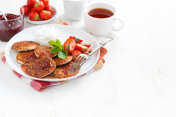Pancakes with fresh strawberries, jam and tea.