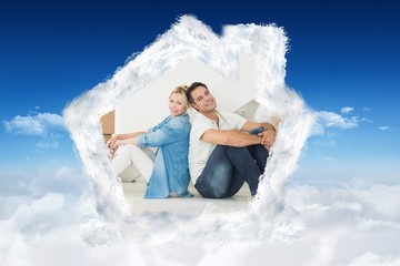 Composite image of smiling couple with boxes in a new house
