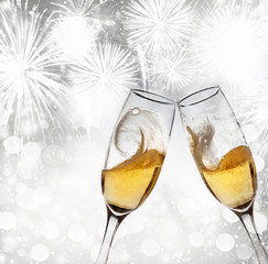 New Year's - toasting with champagne glasses against fireworks a