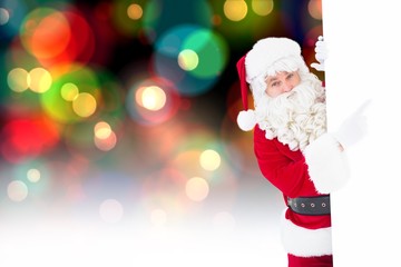 Composite image of smiling santa claus pointing poster