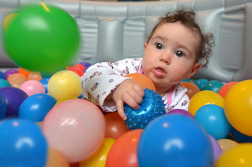 Fototapeta na wymiar Baby plays with colorful balls