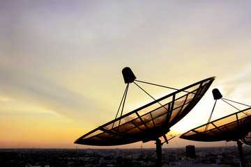 Fototapeta na wymiar Satellite dishes on twilight sky background
