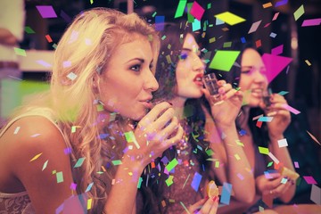 Composite image of happy friends drinking shots together