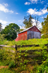 Obraz premium Fence and barn on a farm in rural York County, Pennsylvania.