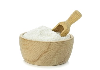 Desiccated coconut in wooden bowl with scoop on white background