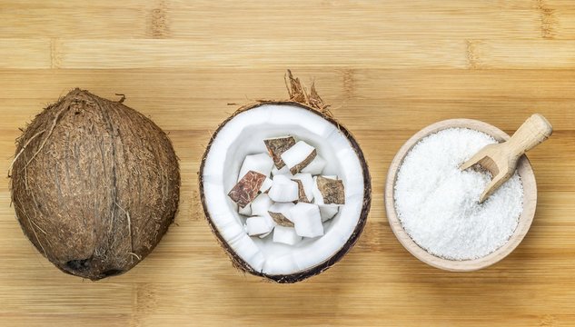 Bowl Of Desiccated Coconut Whole And Chunks On Wooden Background