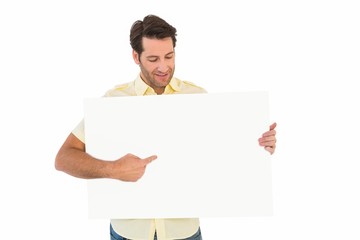 Fototapeta premium Attractive man smiling and pointing white poster