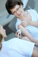Senior woman receiving flu vaccine